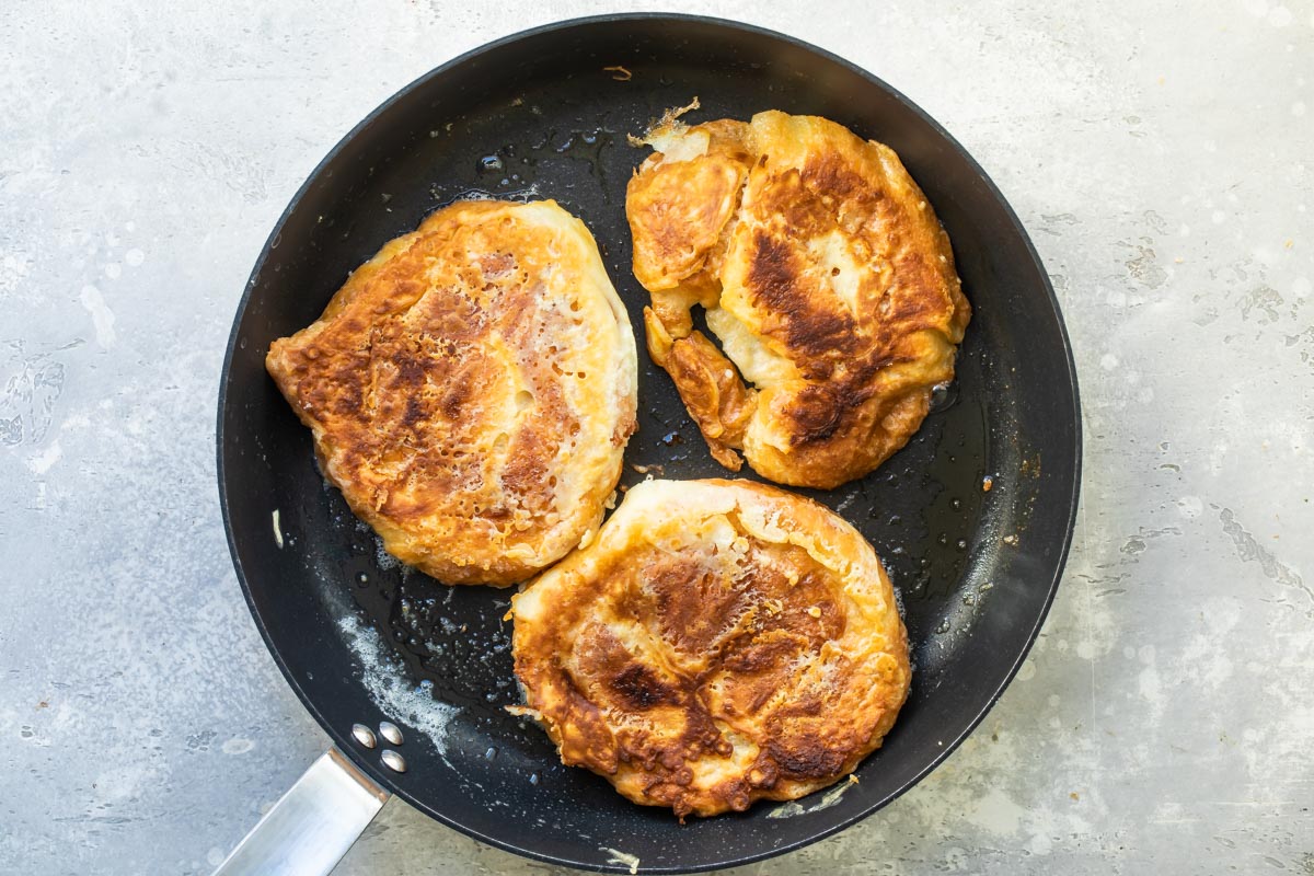 Frying croissant French toast in a skillet.