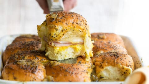 A baking dish of ham and cheese sliders.