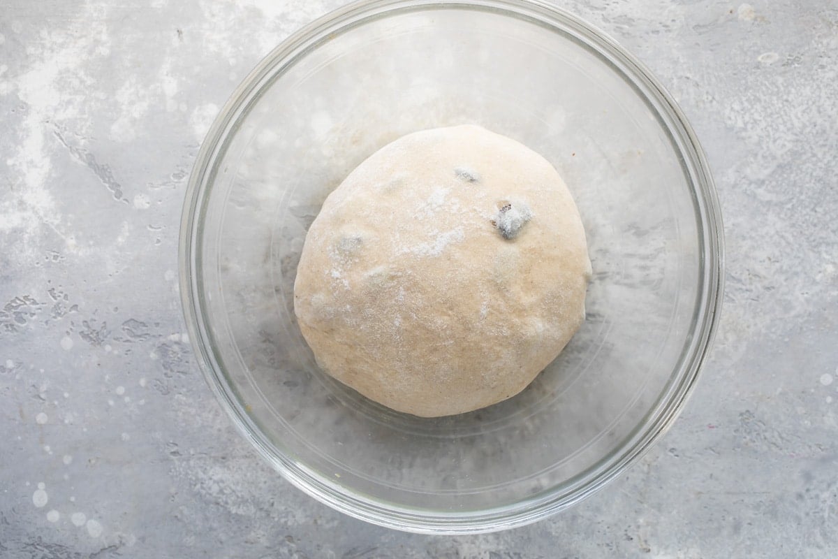 Hot cross bun dough in a clear bowl.