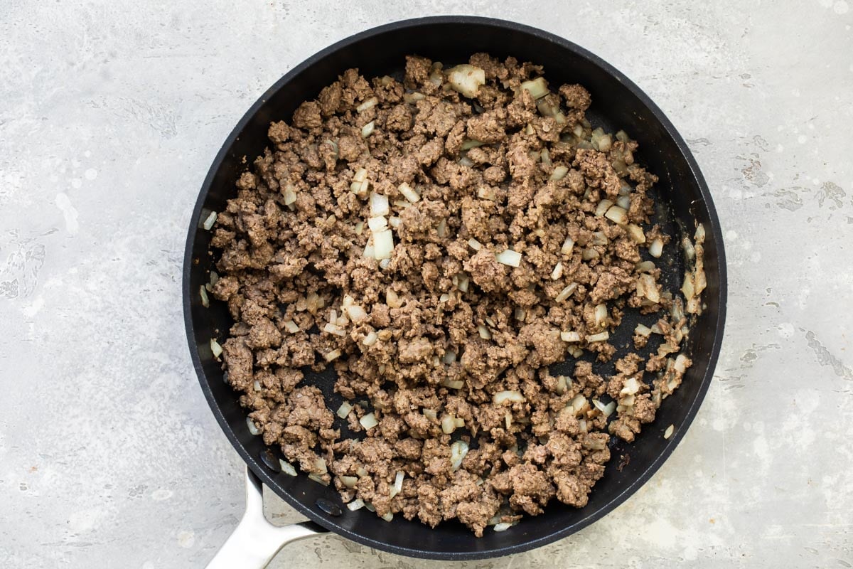 Ground beef and onion cooking in a skillet.