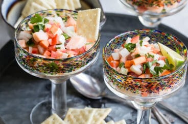 An angled shot of salmon ceviche in stemmed glasses.