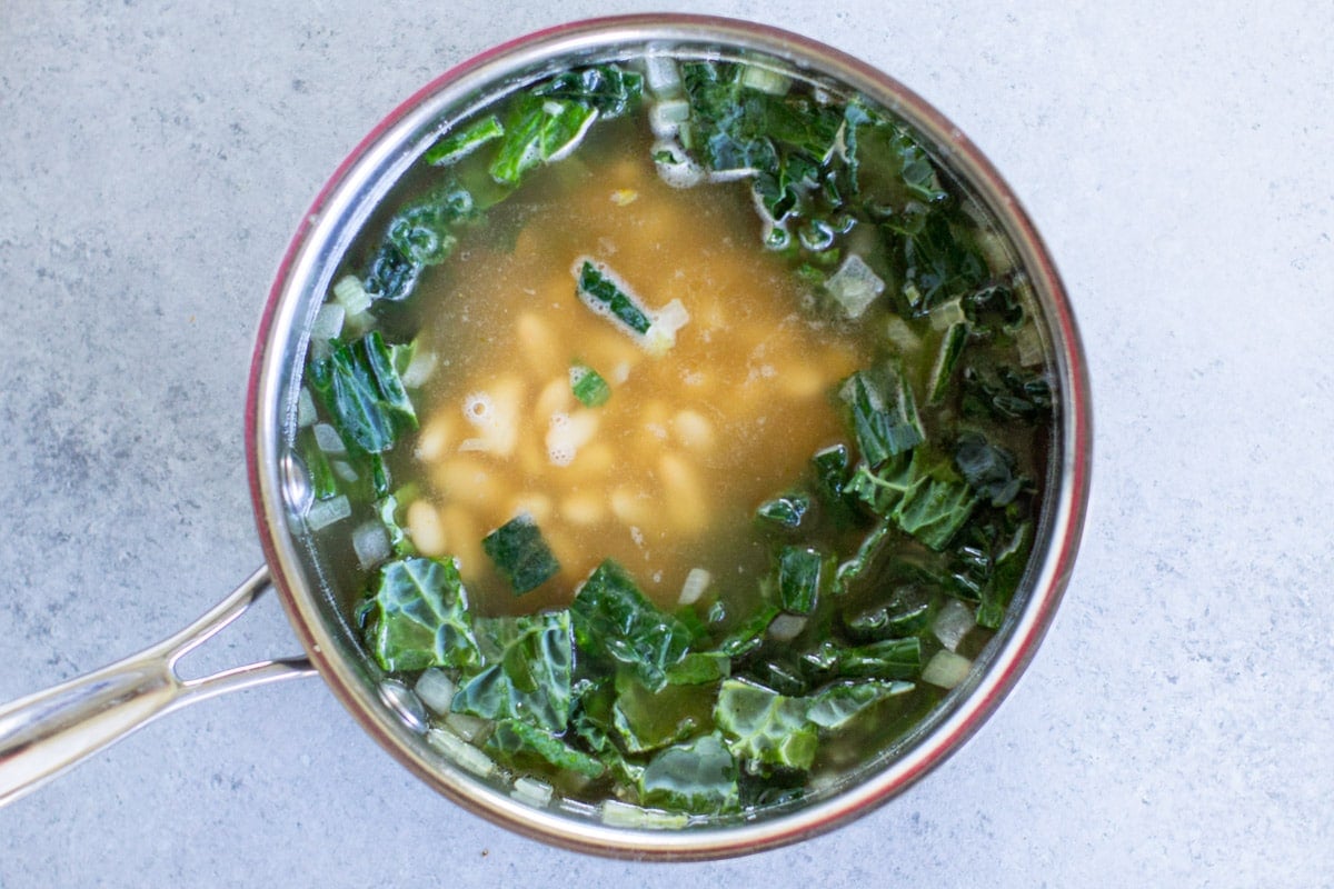 White bean and kale soup in a saucepan.