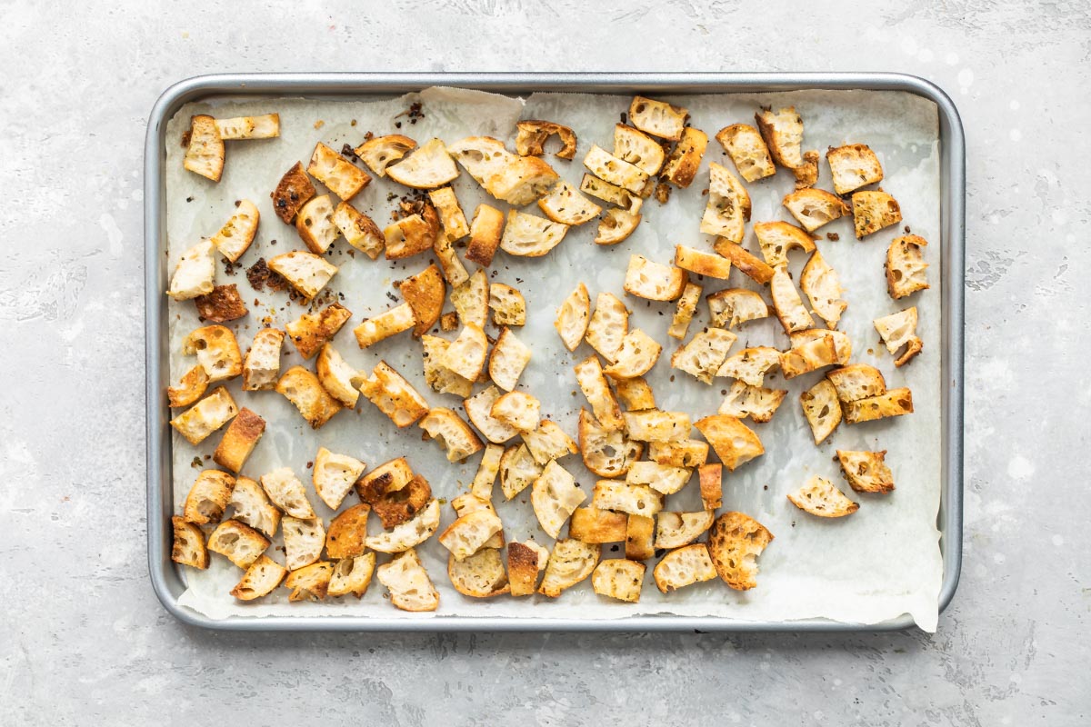 Croutons on a parchment paper lined baking sheet.