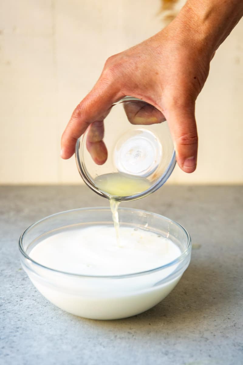 Pouring lemon juice into milk to make buttermilk.