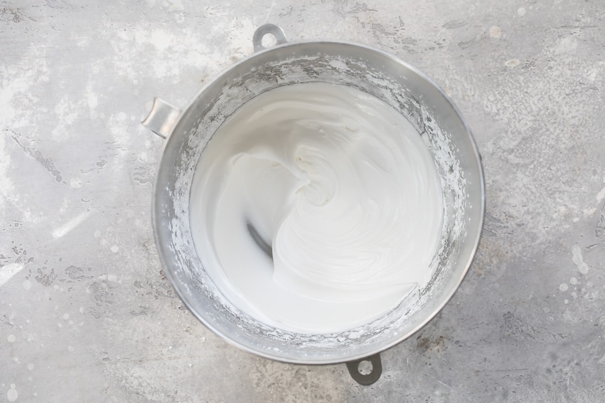 Sugar added to egg whites in a mixing bowl to make royal icing.