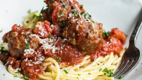 Spaghetti and meatballs on a white platter.