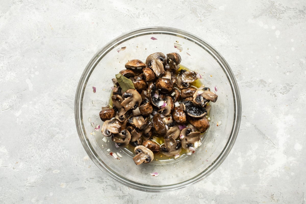 Marinated mushrooms in a clear bowl.