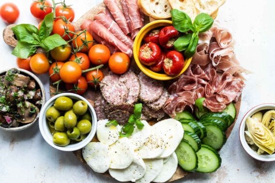 An antipasto platter on a wooden tray.