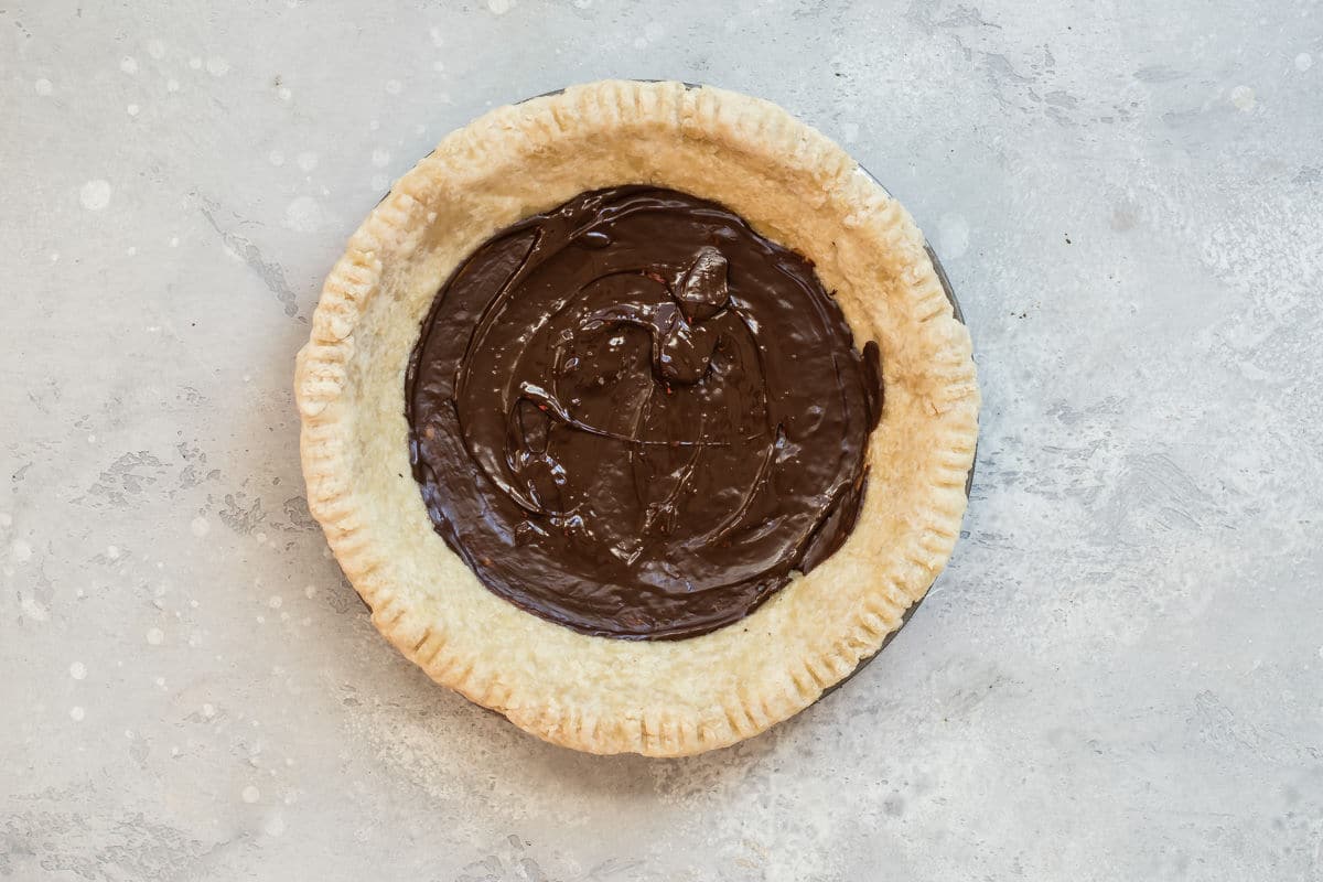 Chocolate spread over a baked pie crust.