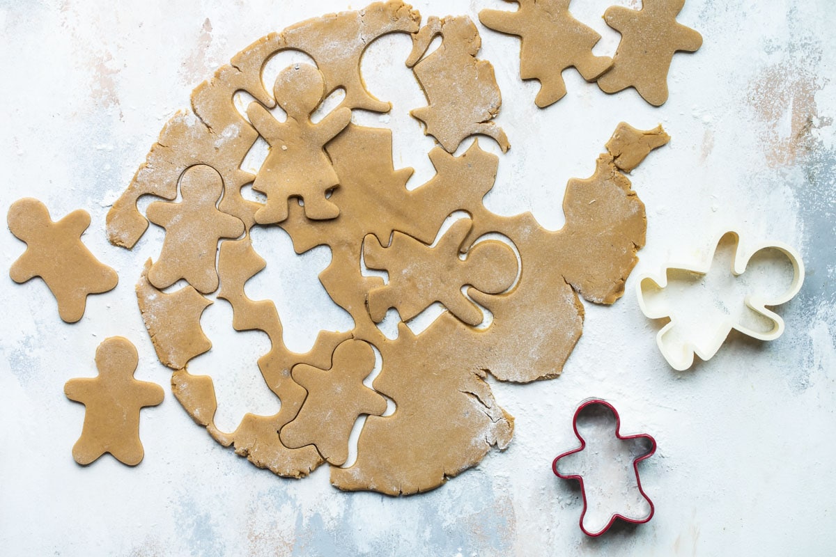 Gingerbread cookie dough rolled out with figures cut out for cookies.
