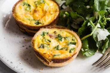 Quiche muffins on a plate with arugula salad.