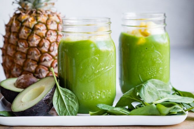 Two mason jars filled with Pineapple Spinach Smoothie.