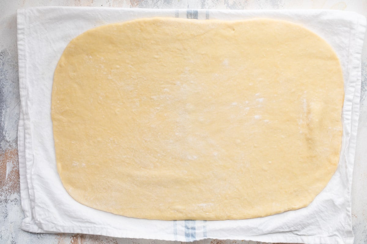 Apple strudel dough on a kitchen towel.