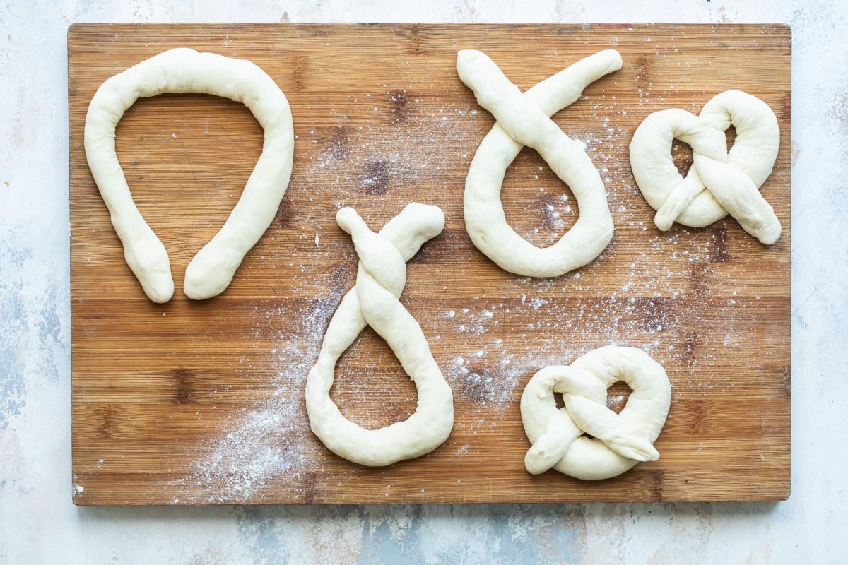 Twisting dough into a pretzel shape.