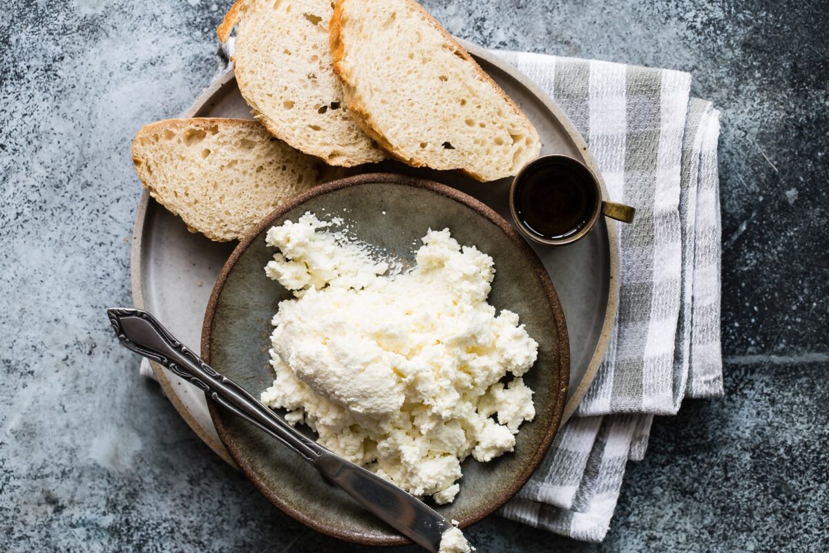 Ricotta cheese in a small dish surrounded by pieces of bread.