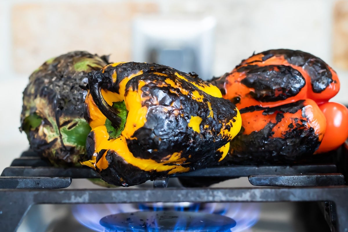Roasting peppers over an open flame gas stove.
