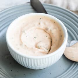 A bowl of remoulade sauce with a spoon next to it.