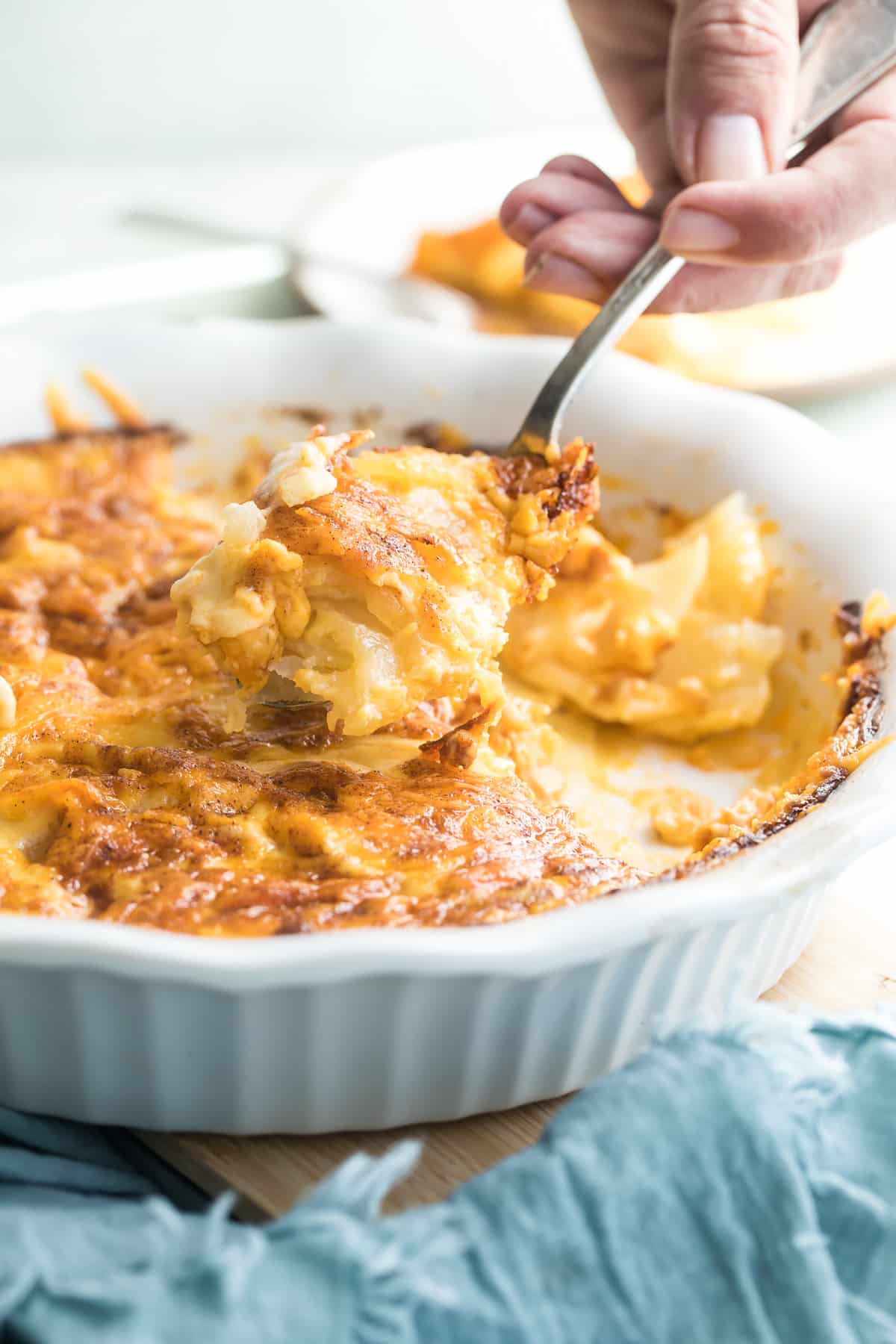 Scalloped potatoes in a white baking dish.