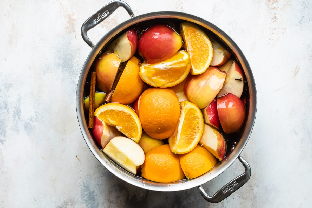 A stock pot with ingredients for apple cider.