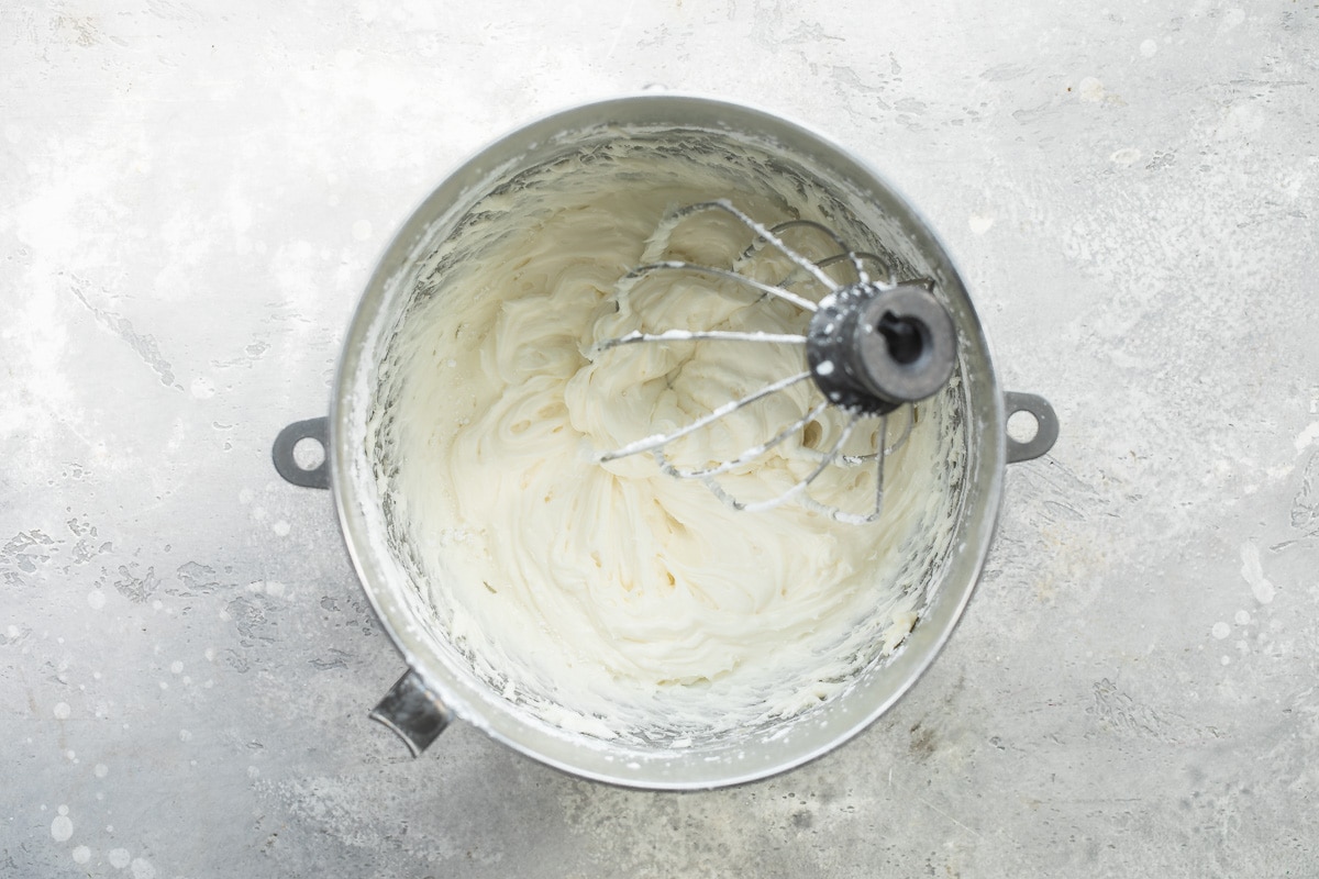 Cream cheese frosting in a silver mixing bowl.