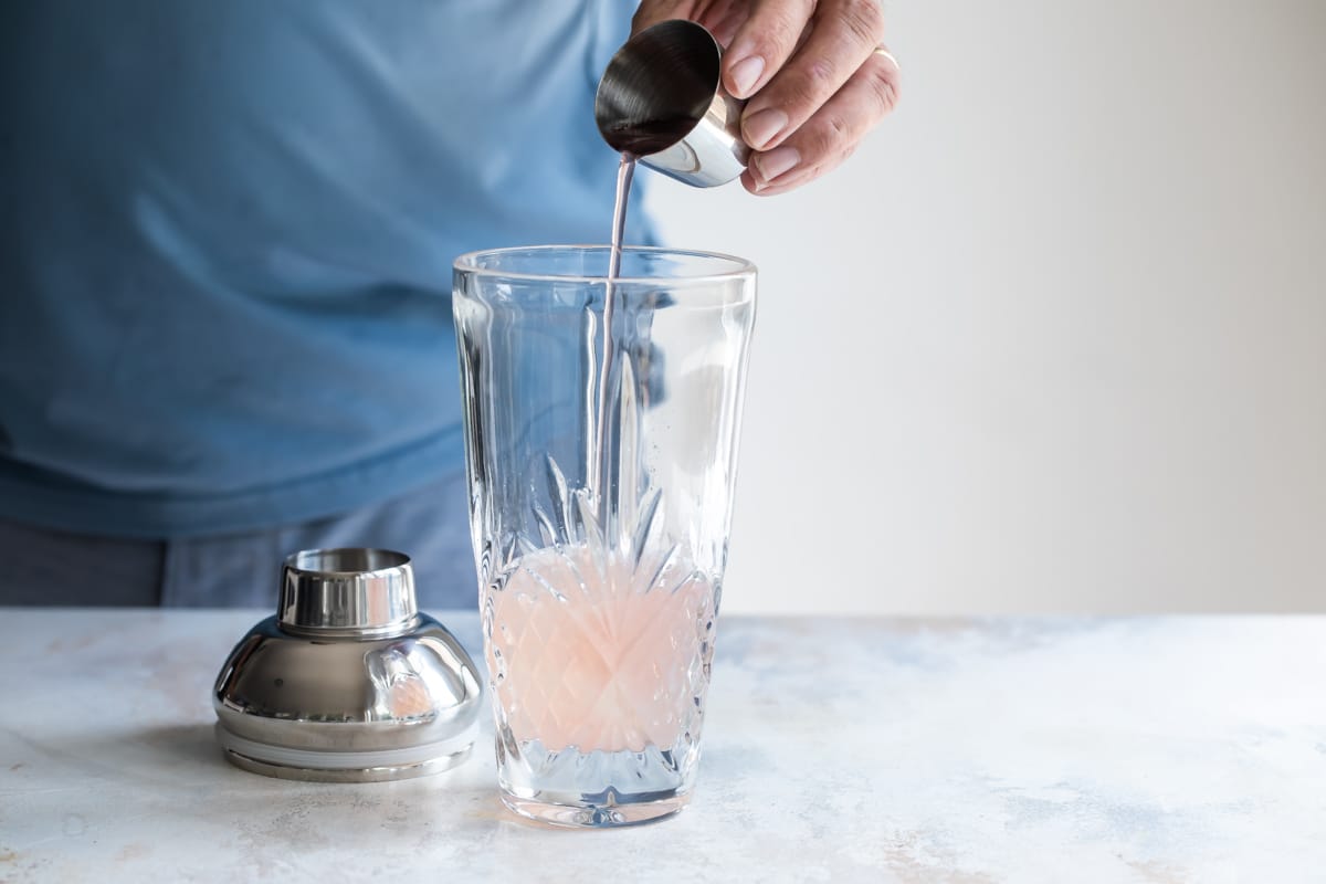 Building a cosmopolitan cocktail in a shaker.