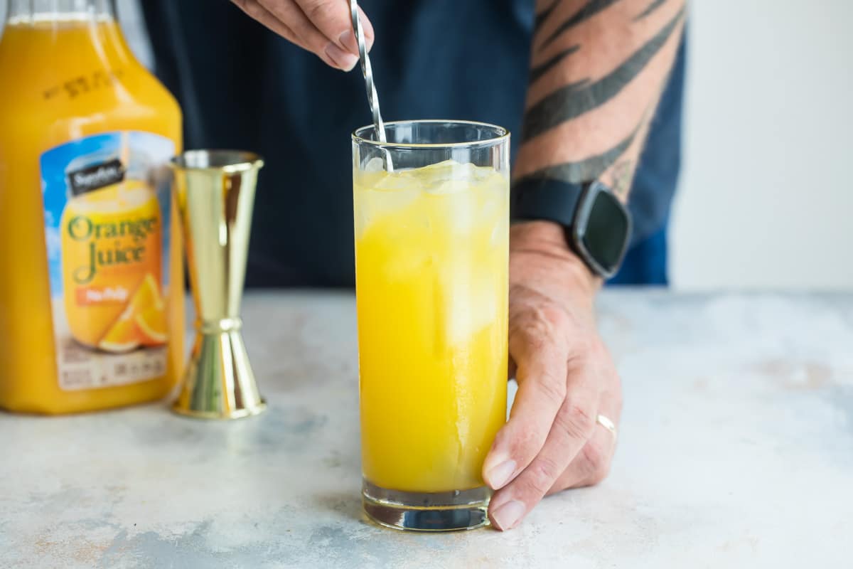 Building a fuzzy navel cocktail.