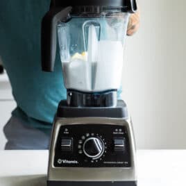 A blender with white liquid being mixed in it.