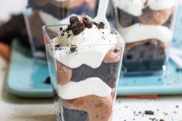 Miniature Oreo brownie trifles in small clear plastic cups.