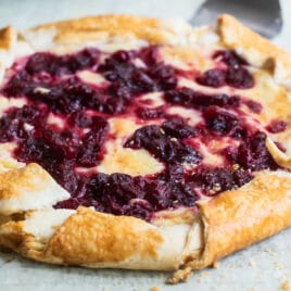 Cranberry cheesecake galette on a piece of parchment paper over a cooling rack.