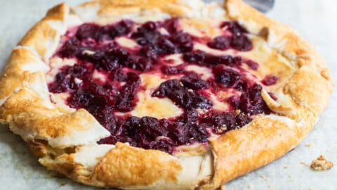 Cranberry cheesecake galette on a piece of parchment paper over a cooling rack.