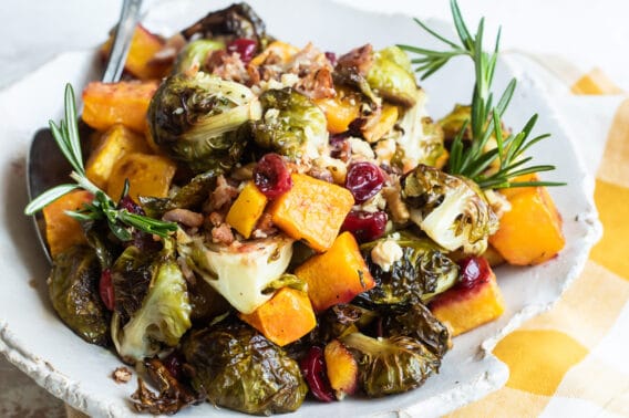 A serving of harvest roasted vegetables on a white plate.