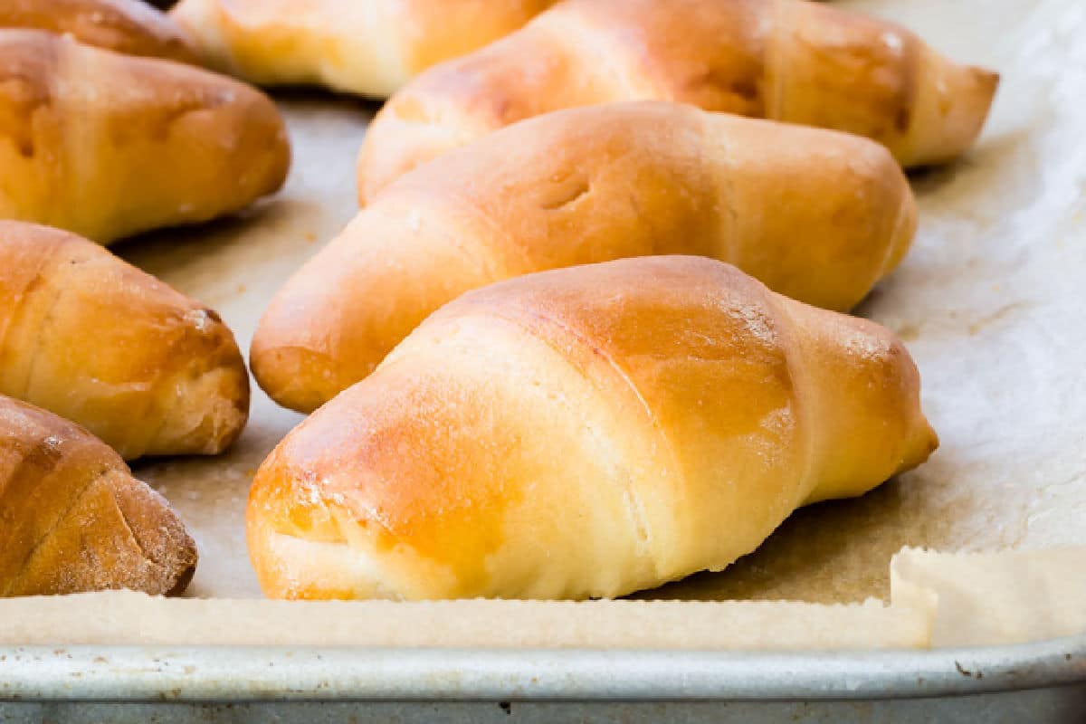 A baking sheet of homemade crescent rolls.