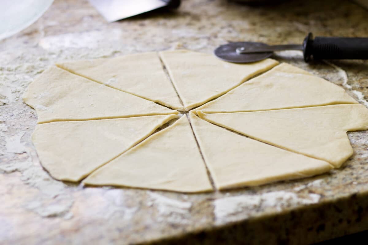 Step-by-step photos for rolling out and shaping homemade crescent rolls.