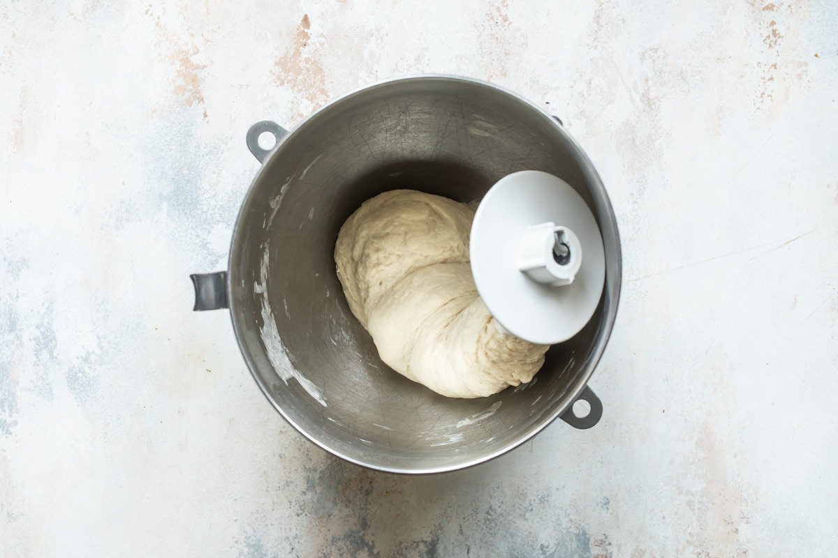 Homemade pita bread dough in a silver bowl.