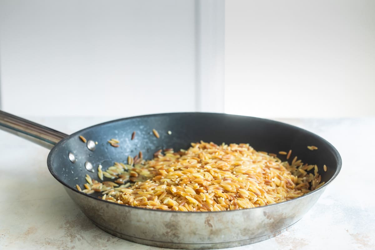 Cooked orzo pasta in a skillet.