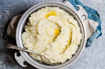 A metal serving dish full of the absolute best mashed potatoes.