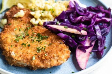 A plate of pork schnitzel, spatzle, and braised red cabbage.