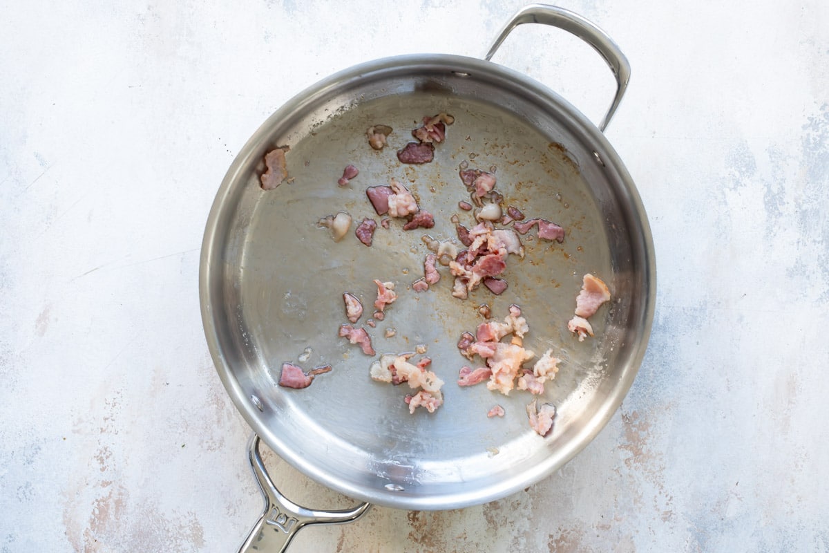 A skillet with cooked bacon.