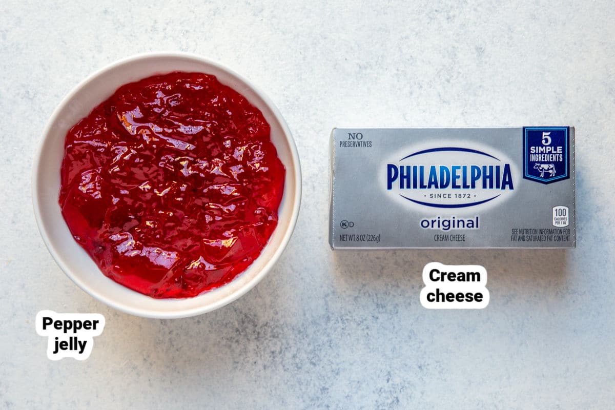 A block of cream cheese next to a bowl of pepper jelly