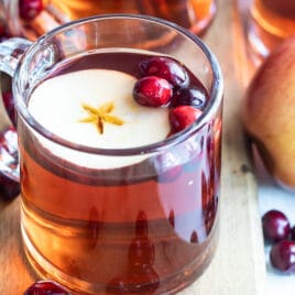 Slow cooker cranberry apple cider in a clear mug.