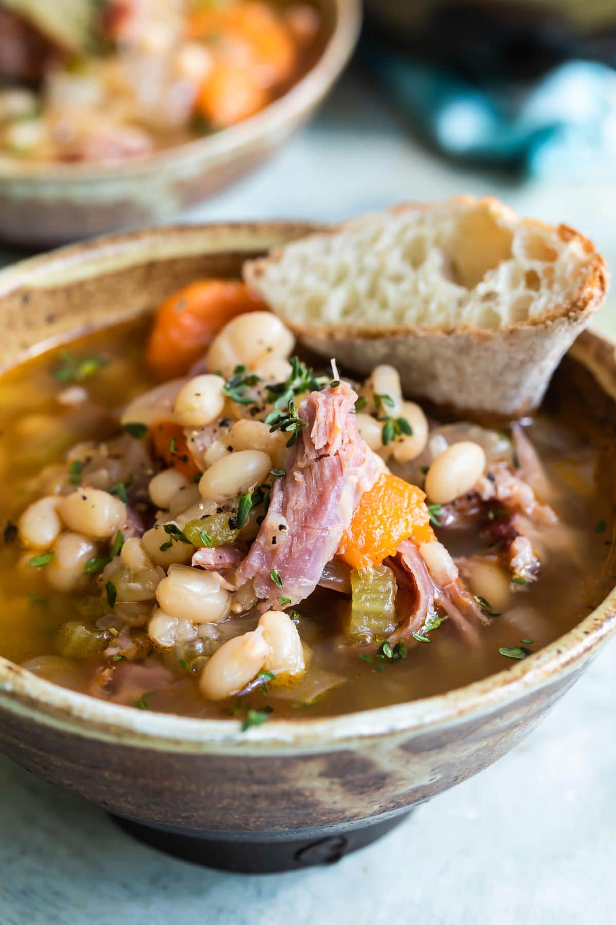 A bowl of ham and bean soup on a table.
