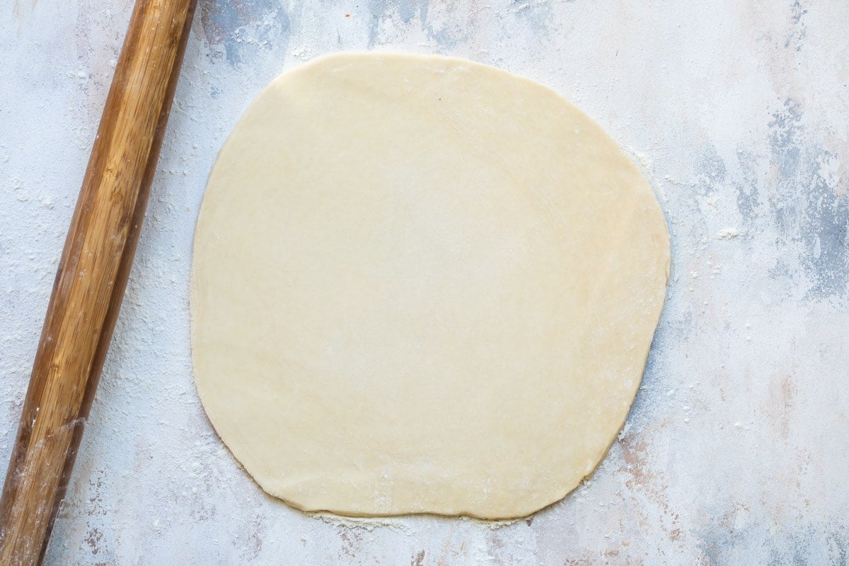 Pie dough rolled out on a board.