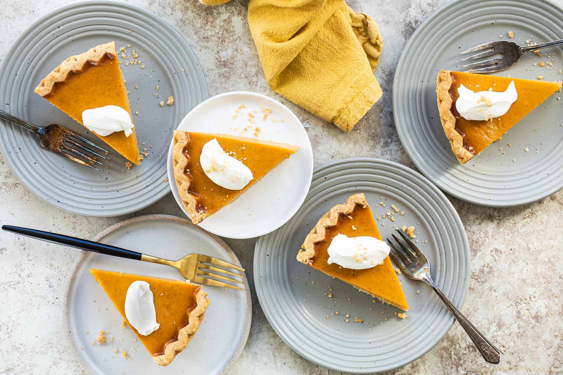 Slices of pumpkin pie on a white plate.