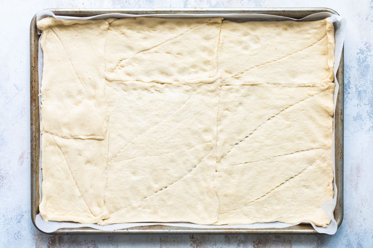 Unbaked crescent roll dough on a baking sheet.