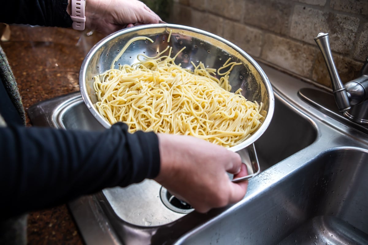 Pasta being drained in a colander.
