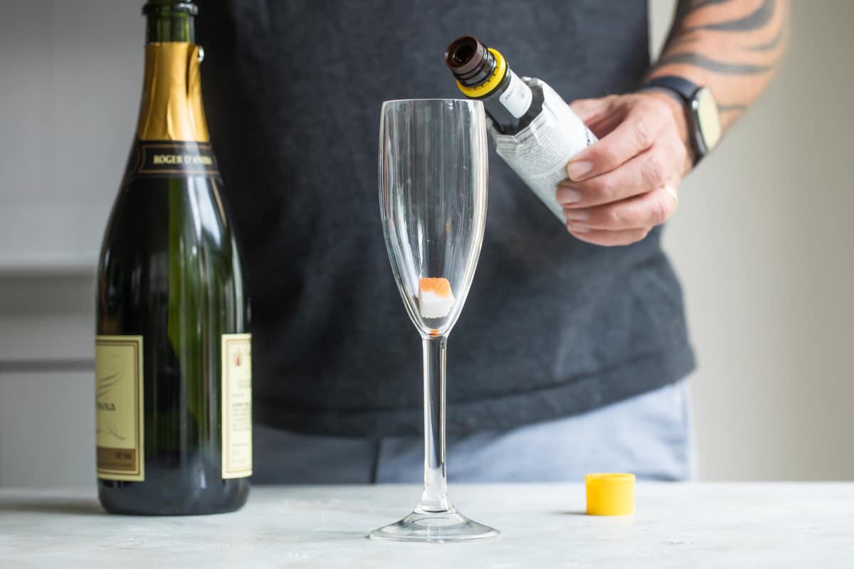 A champagne cocktail being made in a champagne flute.