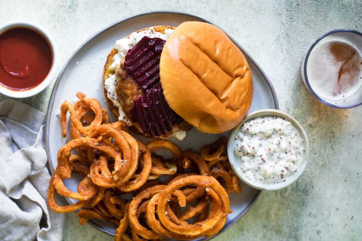 A pork burger with a side of curly fries.