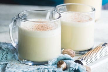 Two clear mugs filled with eggnog.