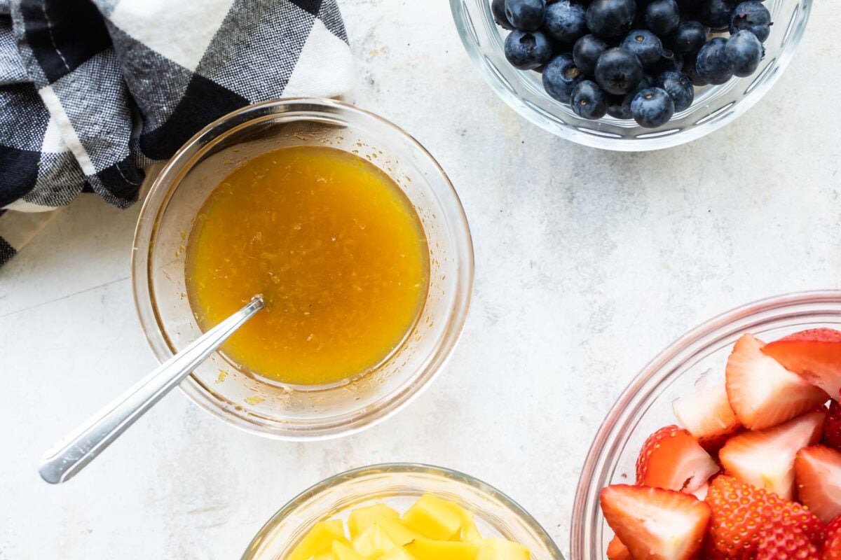 Fruit salad dressing in a small clear bowl.