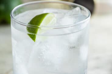 A gin and tonic cocktail in a clear glass.